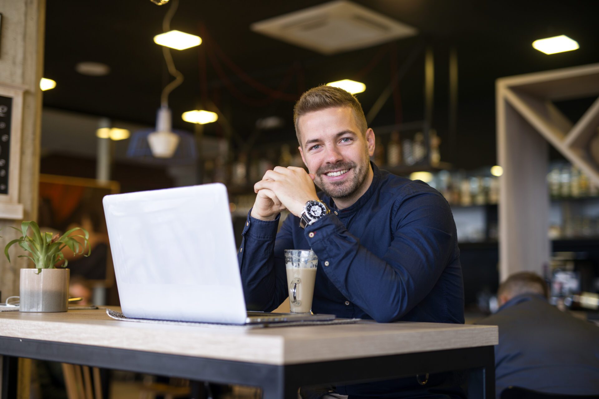 portrait smiling man sitting cafe bar with his laptop computer scaled